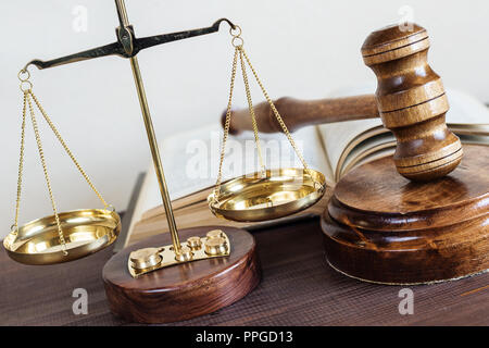 Symbols of law: wood gavel, soundblock, scales and opened volumetric old book Stock Photo