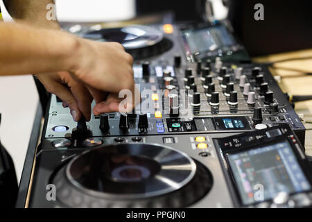 DJ mixing tracks on professional DJ sound controller. Stock Photo