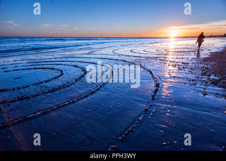 Brighton, UK. 25th Sept 2018. UK Weather: Sunset in Brighton with a particularly low tide, revealing rarely-seen sand on the city's famously pebbled beach. An even lower tide is expected this evening just before 7pm. Credit: Andrew Hasson/Alamy Live News Stock Photo