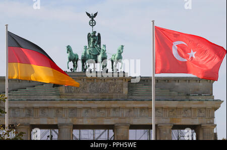 26 September 2018, Berlin: The flags of the Federal Republic of Germany and Turkey fly in front of the Brandenburg Gate. They point to the forthcoming state visit of the President of Turkey, Erdogan. Photo: Wolfgang Kumm/dpa Stock Photo