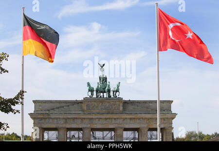 26 September 2018, Berlin: The flags of the Federal Republic of Germany and Turkey fly in front of the Brandenburg Gate. They point to the forthcoming state visit of the President of Turkey, Erdogan. Photo: Wolfgang Kumm/dpa Stock Photo