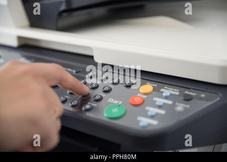 Office worker works with multi-function device and sets the number of copies to print Stock Photo