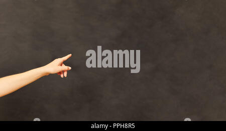 Hand of a teacher pointing to a blank blackboard in the school Stock Photo