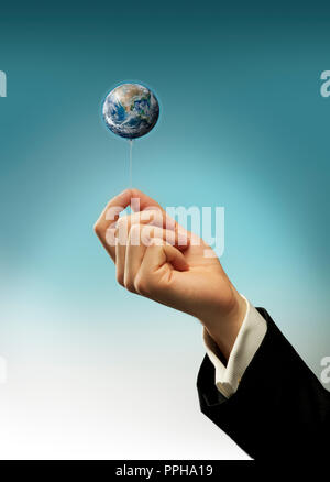 Concept Hand of a business man holding a string of earth balloon Stock Photo