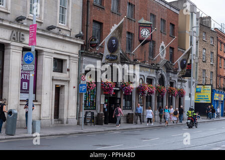 Dublin, Ireland -- July 9, 2018.  Pedestrians are walking past the front of a pub in Dublin, Ireland. Stock Photo