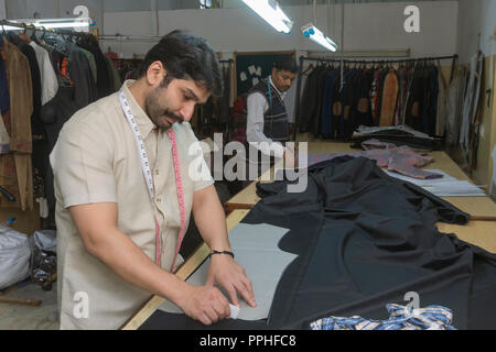 Tailor making markings on cloth in his workshop. Stock Photo