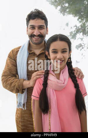 Portrait of a smiling village man standing with his daughter. Stock Photo