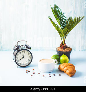 morning breakfast ,coffee in a white cup Croissant Avocado Lime on a light background Awakening with an alarm clock Cheerful, healthy breakfast fresh  Stock Photo