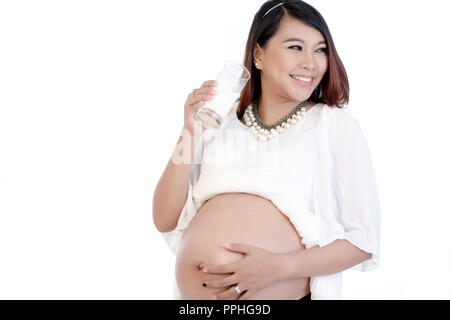 Smiling pregnant woman drinking glass of milk Stock Photo