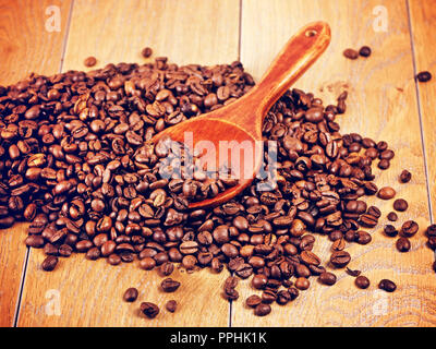 wooden spoon with coffee beans on table Stock Photo