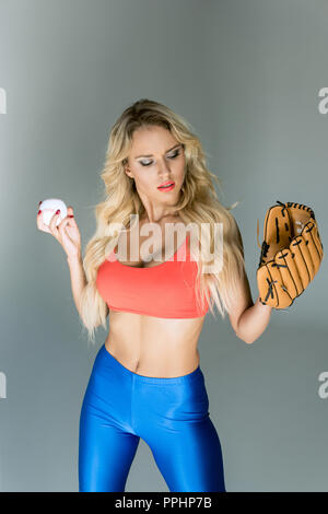 fit young woman in sportswear with baseball glove and ball Stock Photo