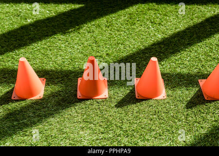 high angle view of row of safety cones standing on grass field Stock Photo