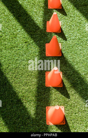 high angle view of row of safety cones standing on green grass Stock Photo