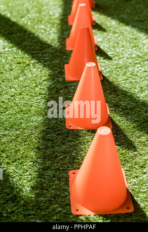 row of safety cones standing on green grass Stock Photo