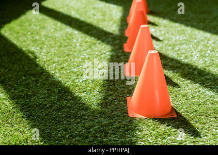 close-up shot of row of safety cones standing on green grass Stock Photo