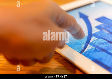 Financial concept close up hand pointing tablet screen with stoc Stock Photo