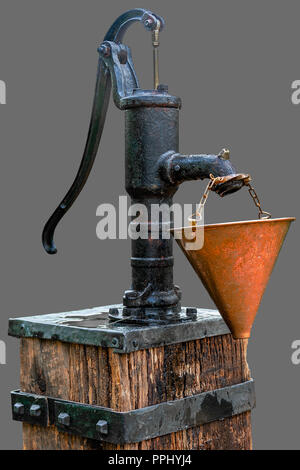 Old cast iron manual water pump on isolated gray background with clipping path. Stock Photo