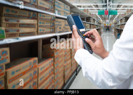 A worker scanning cargo with bluetooth barcode scan. Reading and scanning barcode on the cargo in a warehouse. Stock Photo