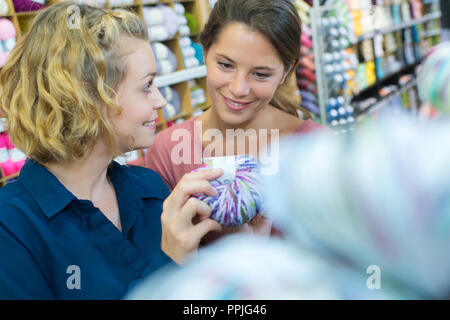 two women buying threads in a store Stock Photo