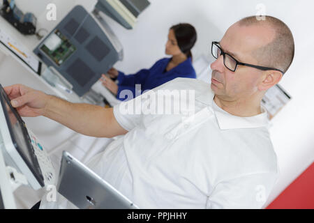technician using tablet pc while analysing server Stock Photo