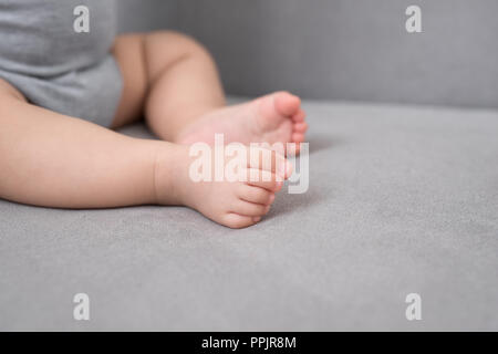 Baby's foot on sofa in the room, close up Stock Photo