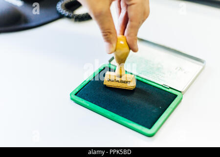A wooden stamp with the german word "digitalisiert" which means "digitized" is pressed on a green inkpad Stock Photo