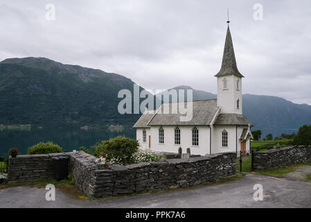 Norwegian church - Nes kyrkje, Commune Luster, Norway. Near Lusterfjord fjord. Old stone fence. Overcast northern weather Stock Photo