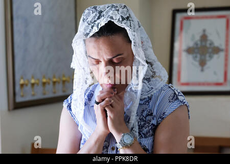 Christian woman with headscarf prays in a church in the Kurdish region, North Iraq Stock Photo