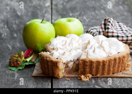 Tasty  meringue pie with rhubarb and apple on wooden table Stock Photo