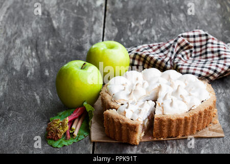 Tasty  meringue pie with rhubarb and apple on wooden table Stock Photo