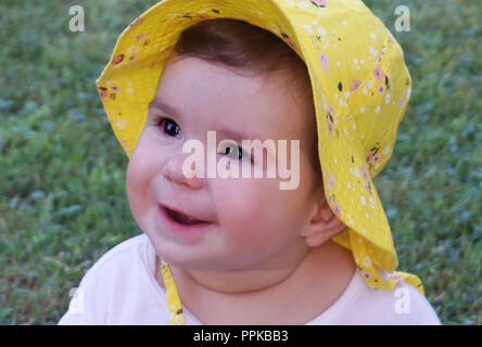 Close up baby face outdoor. Beautiful baby with black eyes smiling Stock Photo
