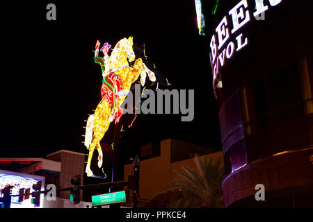 LAS VEGAS, NEVADA, USA - MAY 22, 2018: night streets of the city, a neon stand of a cowboy on a horse Stock Photo
