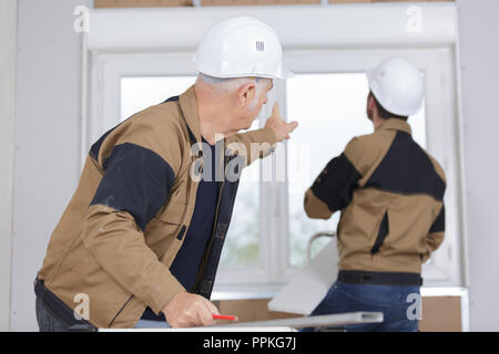 construction workers installing window in house Stock Photo