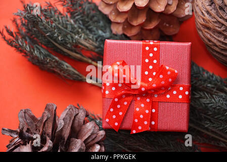 Red gift boxes and pine cones on red background Stock Photo