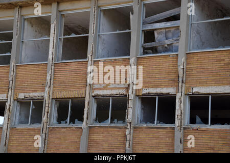 old abandoned factory in sardinia, lost place factory facade, broken windows house facade Stock Photo