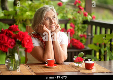 happy aged woman drinking coffee at home Stock Photo