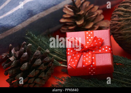 Red gift boxes and pine cones on red background Stock Photo