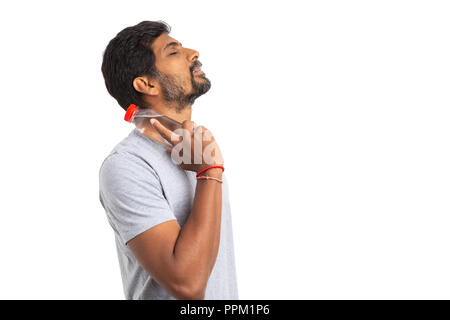 Side-view picture of indian man touching neck with water bottle made of plastic isolated on white background Stock Photo