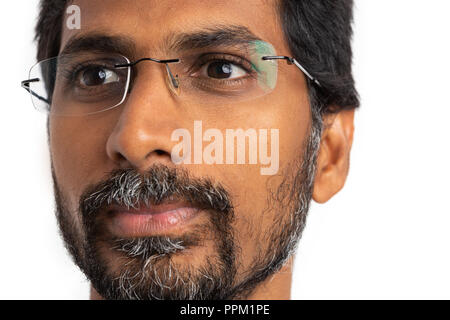 Close-up with the face of indian man not looking at camera wearing eyeglasses or spectacles as optics concept isolated on white background Stock Photo