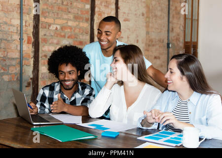 Team of international programmers at work in stylish hipster office Stock Photo