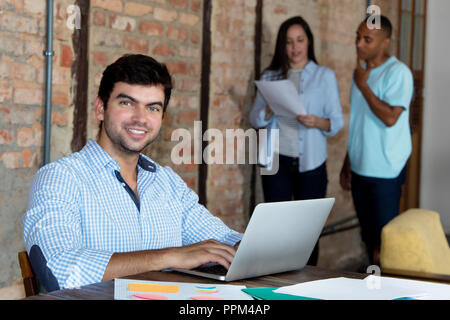 Smart caucasian software developer with computer at office of start up company Stock Photo