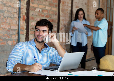 Caucasian software developer with computer at office of start up company Stock Photo
