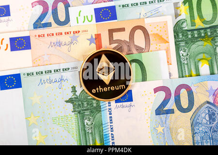 Cryptocurrency coin Ethereum lying on the euro banknotes. Business concept of new virtual money Stock Photo