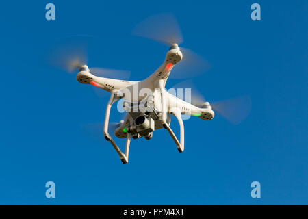 Niedernhausen, Germany, April 9th, 2017, Quadcopter drone DJI Phantom flying into blue sky Stock Photo