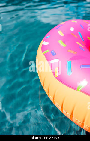 close-up shot of inflatable ring in shape of donut floating in swimming pool Stock Photo