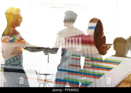 Silhouette of young workers shaking hands in the office. concept of teamwork and partnership. double exposure Stock Photo