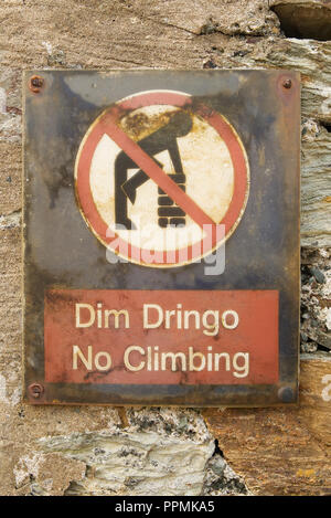 Welsh language No Climbing Dim Dringo sign on an old stone wall with symbol of man climbing on a wall in a red circle with red line through Stock Photo