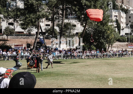 Jerusalem, Israel. 27th September, 2018. Opening the Jerusalem Parade, skydivers from the Israeli Association for Parachuting perform an exhibition landing in Sacher Park in celebration of the city's 50th anniversary of reunification. One jumper miscalculated his approach and landed among the spectators. There were no injuries. Credit: Nir Alon/Alamy Live News Stock Photo