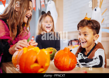 Two sisters and one brother wearing Halloween costumes feeling happy and cheerful Stock Photo