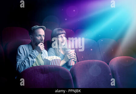 Teenager couple cuddling and watching the climax part of the movie Stock Photo